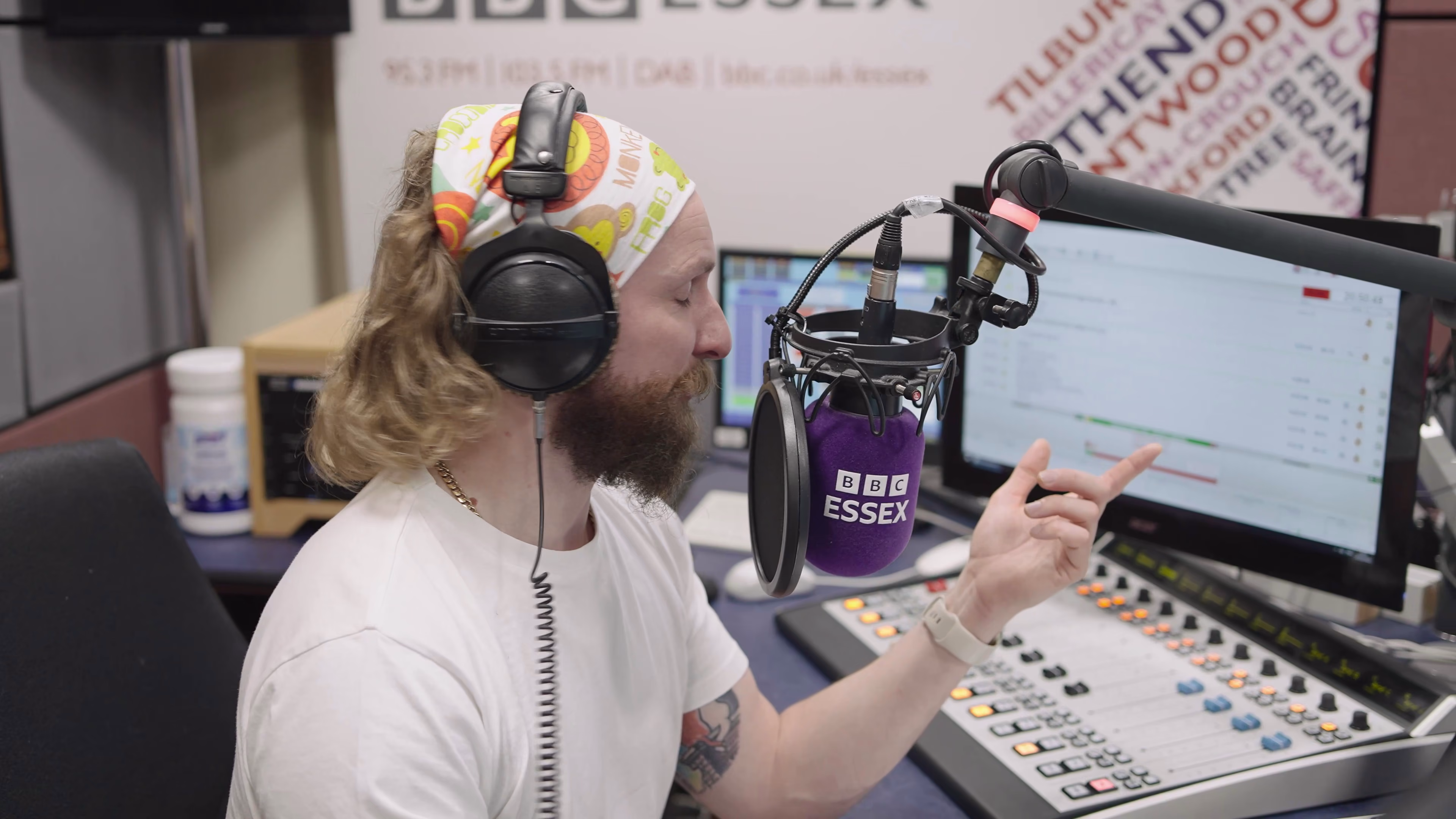 Radio presenter gesturing during a live conversation